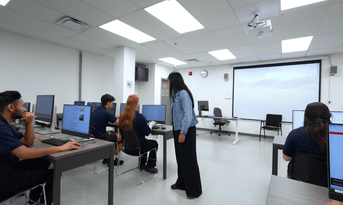 Students working with an instructor in the Ace Acumen Heights computer lab